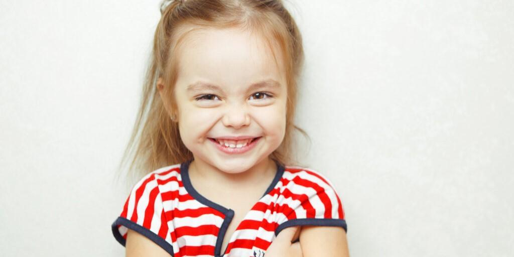 zgrzytanie zębami u dzieci - zdjęcie przedstawia uśmiechającą się dziewczynkę
